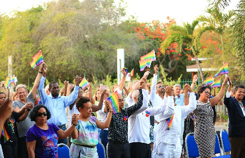 a crowd waving rainbow flags